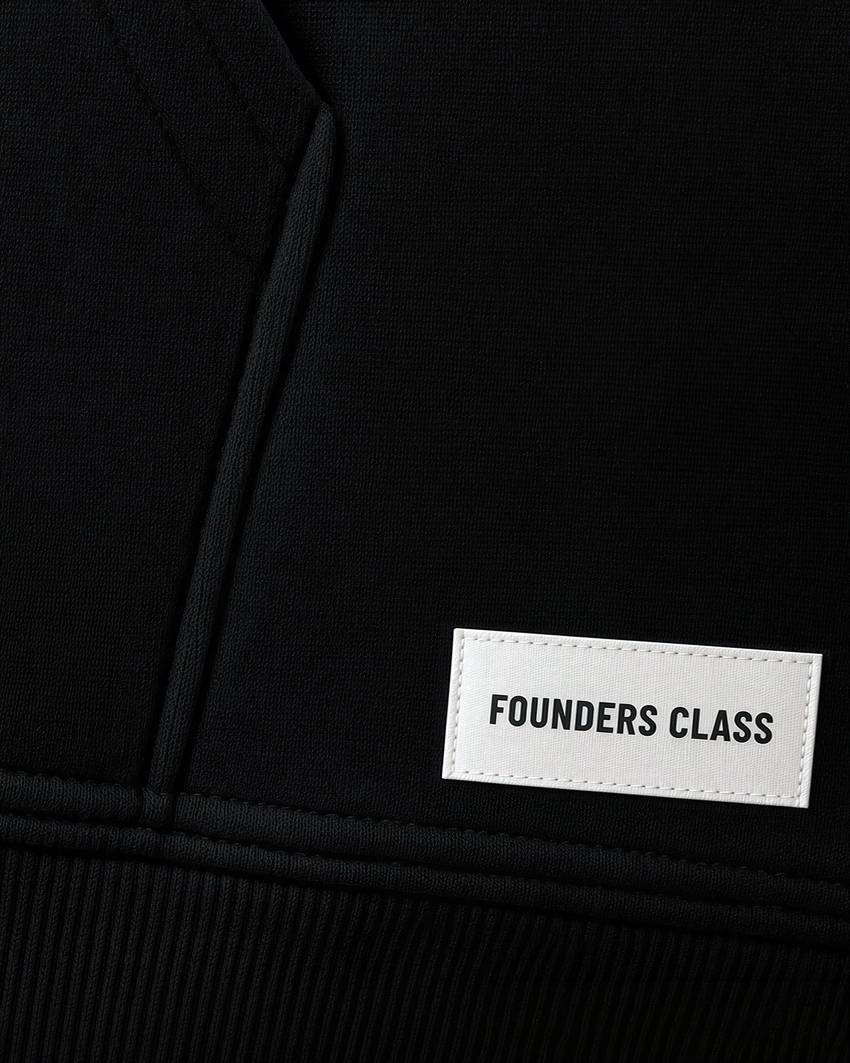 FOUNDERS CLASS woven label sewn above the left hem of the black hoodie #Color_Black