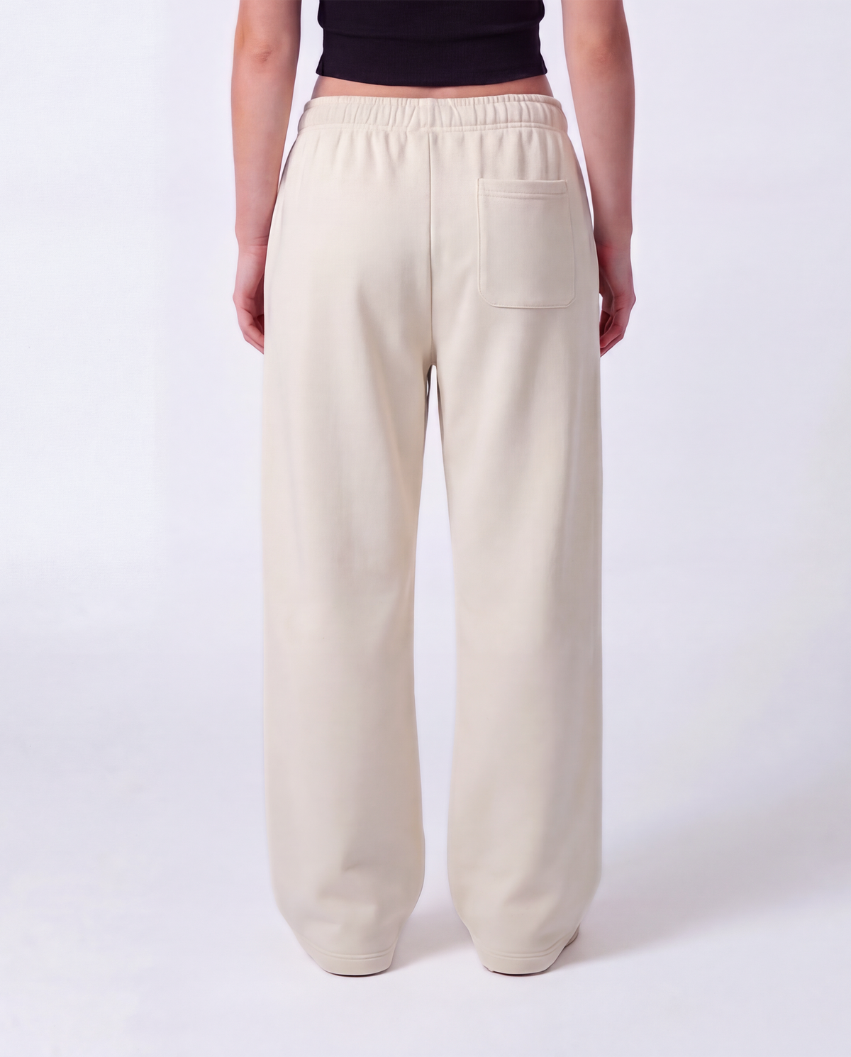 Essential Logo — Carrier Sweatpant — Female model close back (Reese), Bone #Model_F #Color_Bone